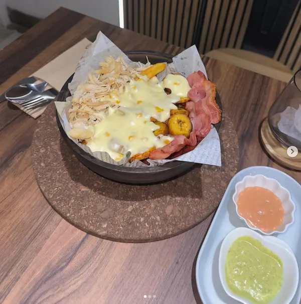 Bandeja para compartir con chicharrón, pollo, queso fundido y plátano